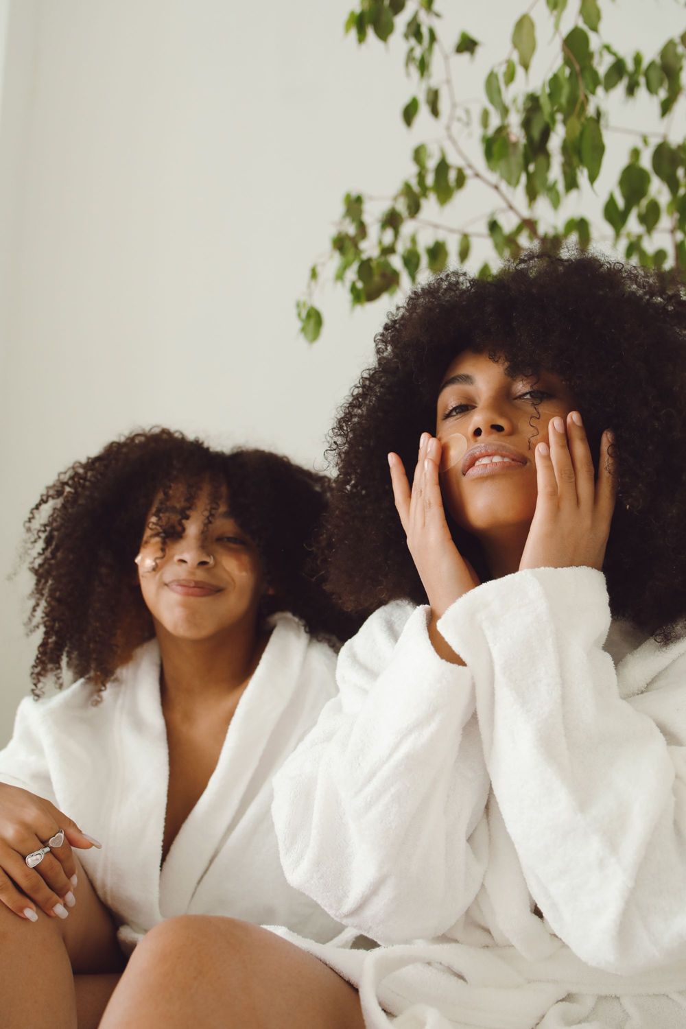 Dos mujeres en bata disfrutando de su rutina de cuidado